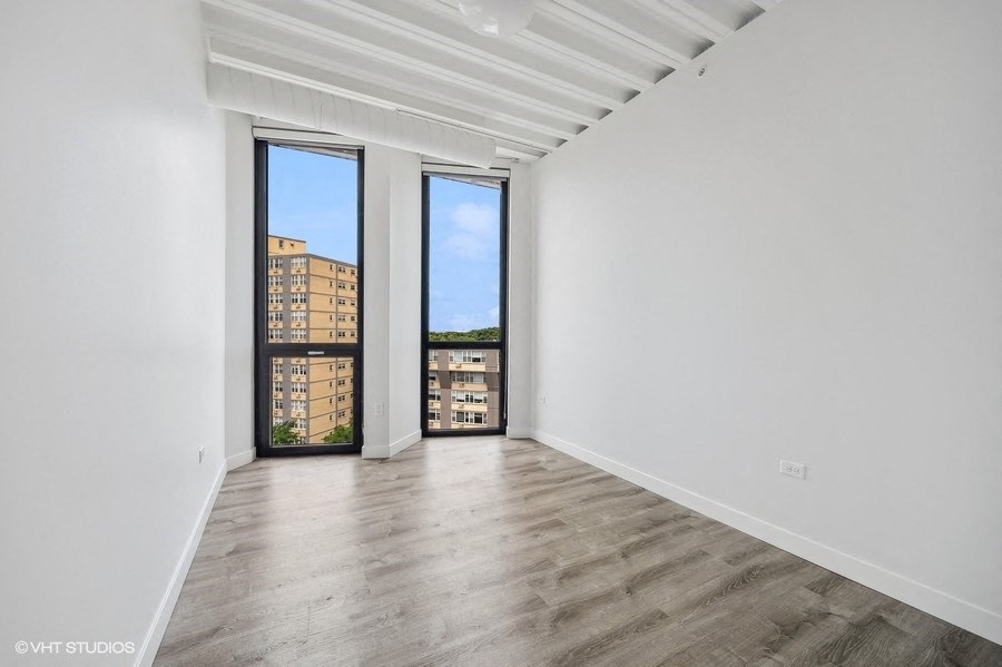 a living room with white walls and a large window