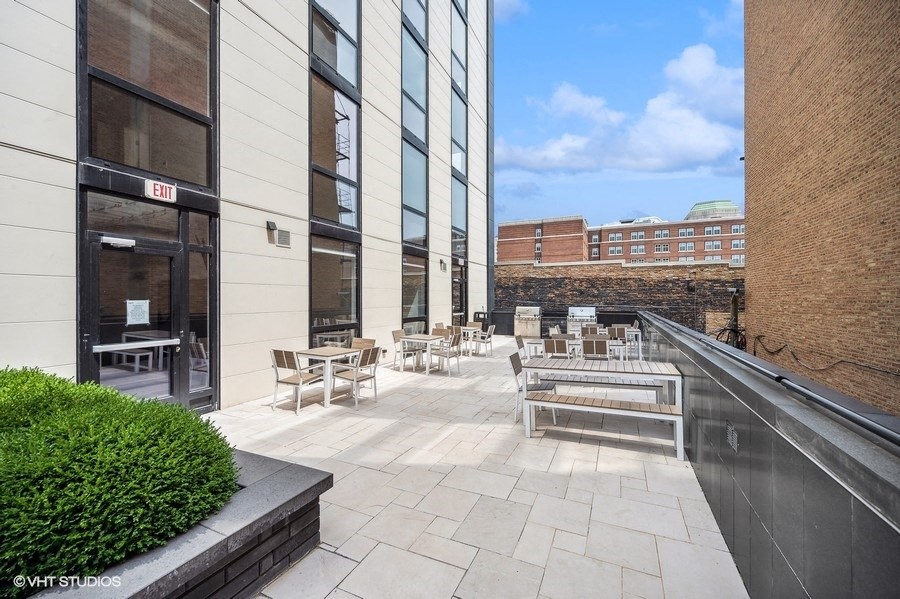 a patio with tables and chairs outside of a building