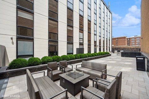 an outdoor patio with tables and chairs in front of a building