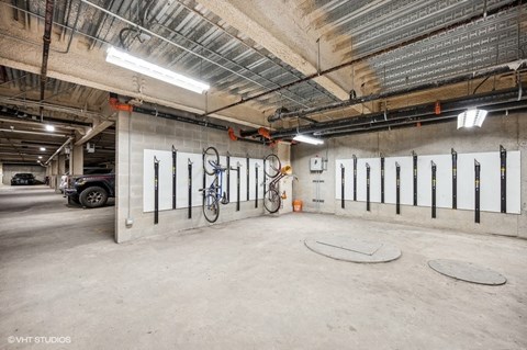 the underground parking garage of a building with a bike on the wall