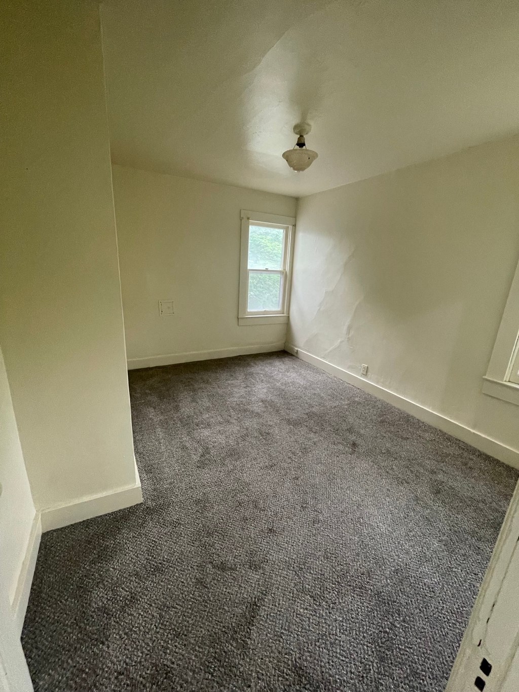 an empty room with carpet and a window