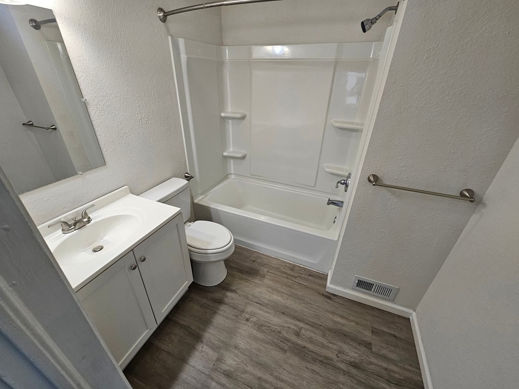 A white bathroom with a toilet, sink, and bathtub.