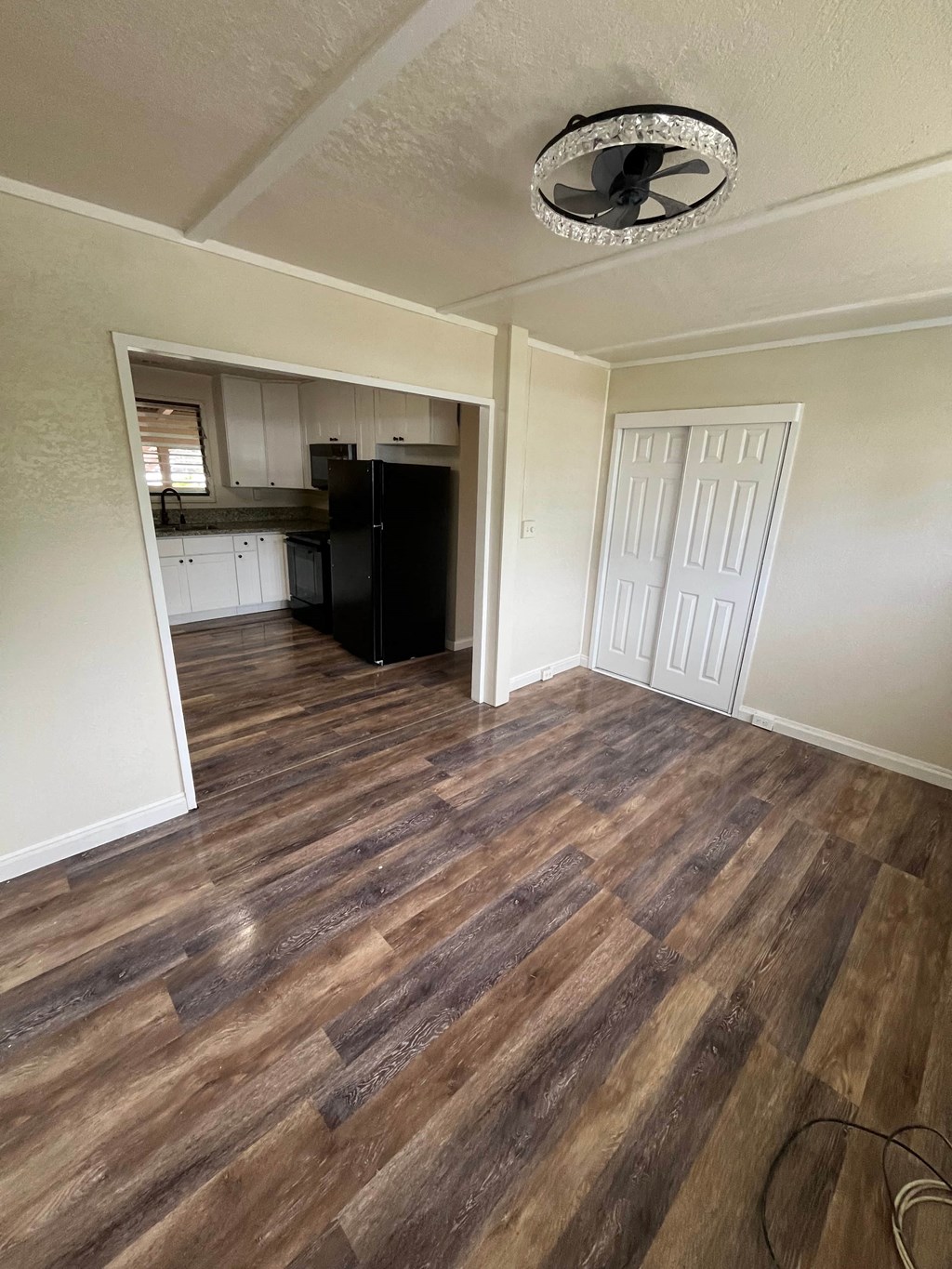 an empty living room and kitchen with wood flooring