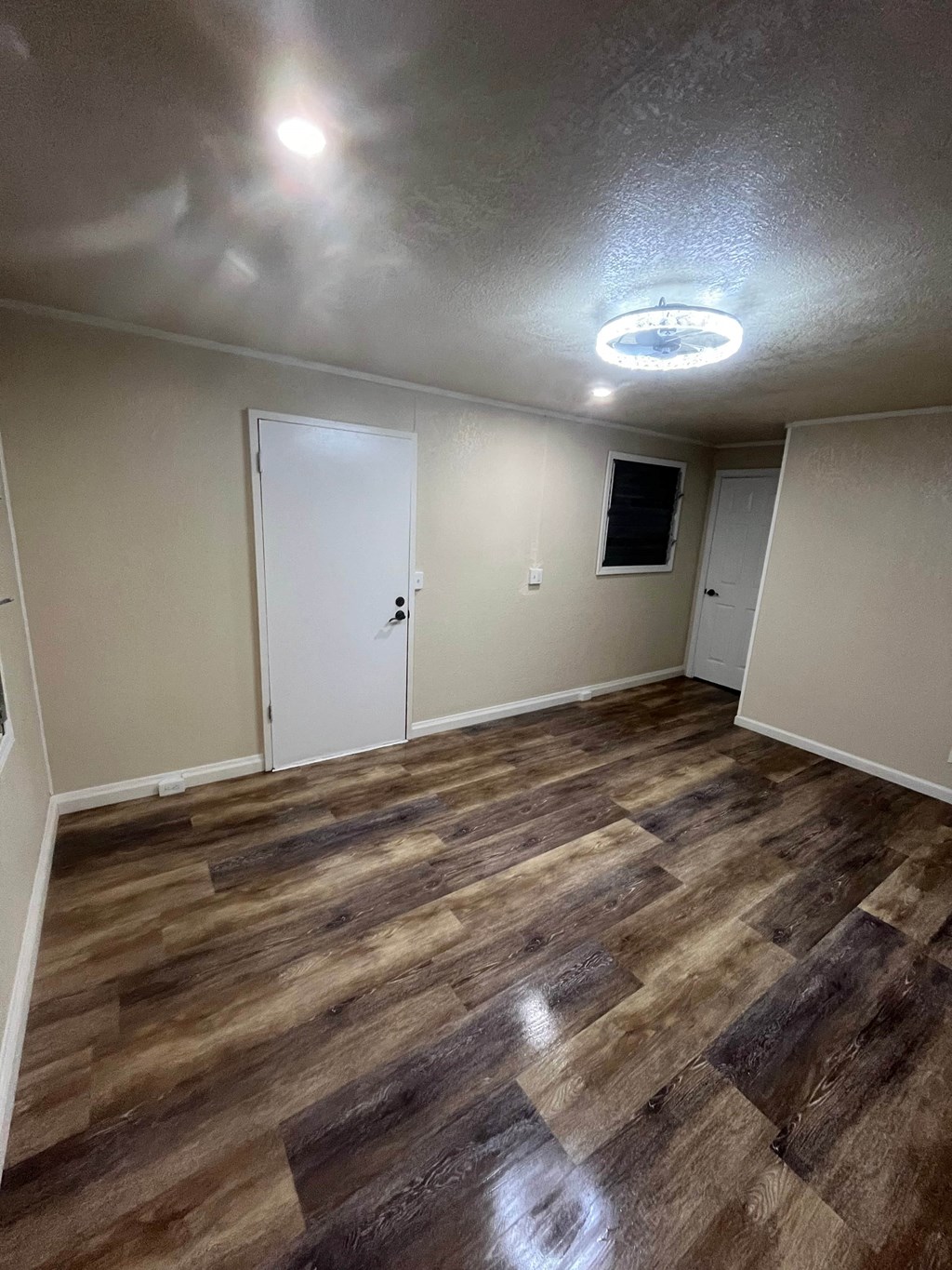a empty living room with wood flooring and white walls