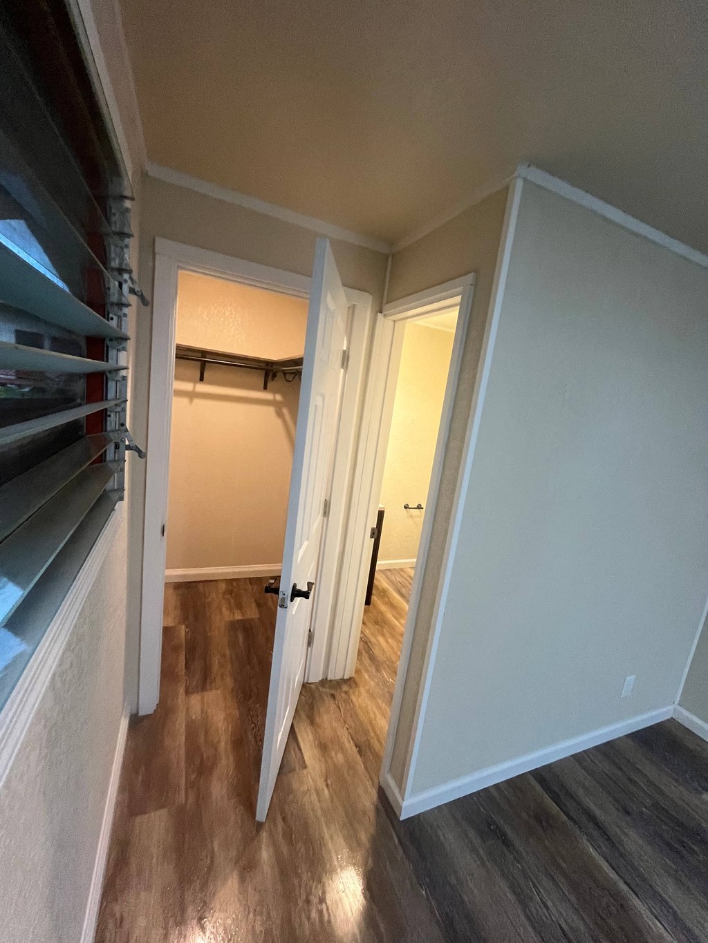 a bedroom with a closet and a hallway with a door open to a closet