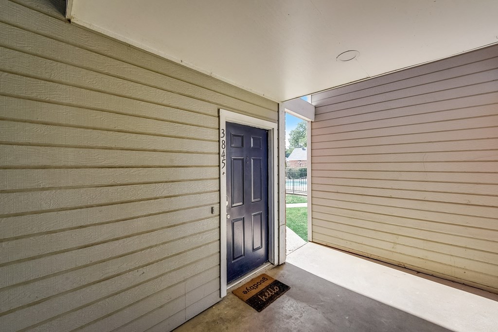 the entrance to a home with a blue door and a porch