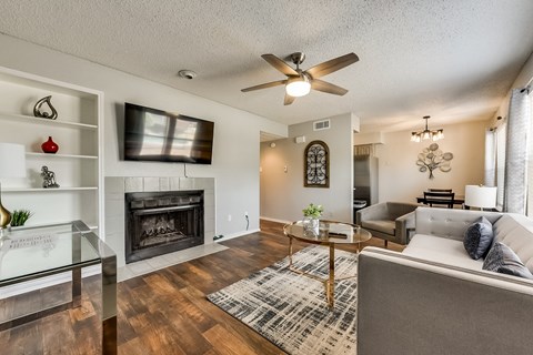 a living room with a fireplace and a ceiling fan