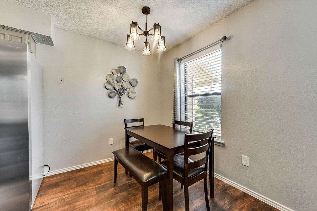 a dining room with a table and chairs and a window