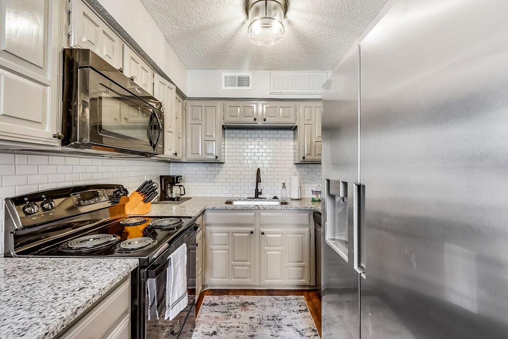 a kitchen with stainless steel appliances and white cabinets