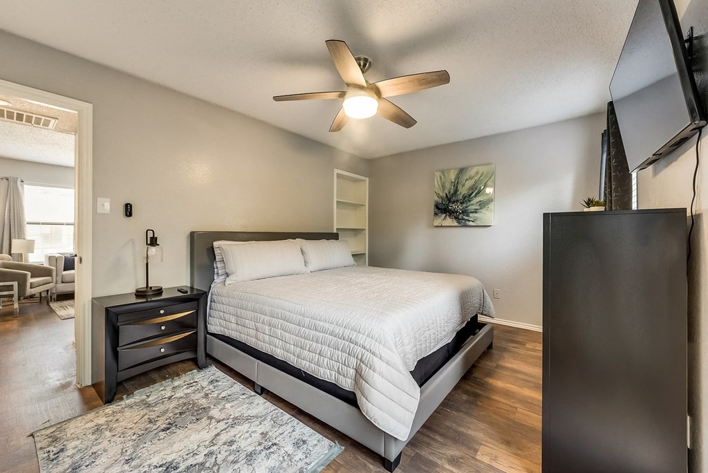 a bedroom with a bed and a ceiling fan