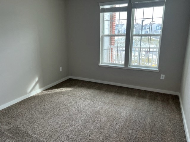 an empty room with carpet and a window