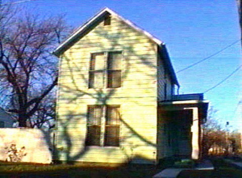 a yellow house with a shadow of a tree on it