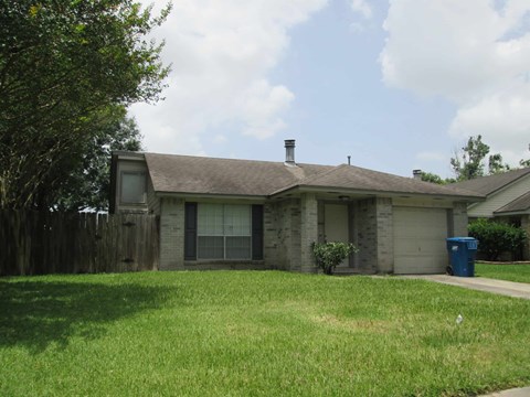 A house with a grey roof and a green lawn.