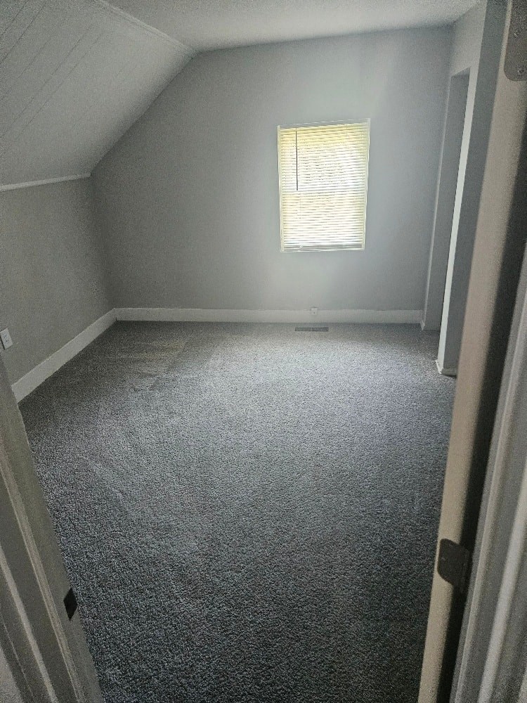 a room with a carpeted floor and a window
