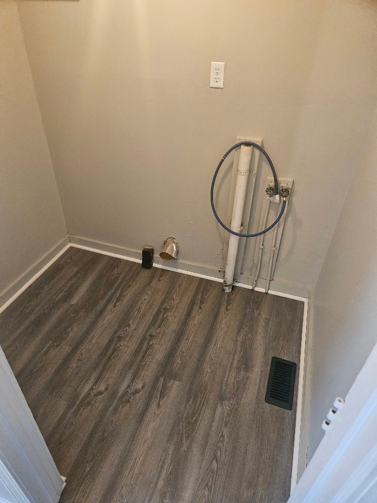 a bathroom with a towel rack in the corner of a room