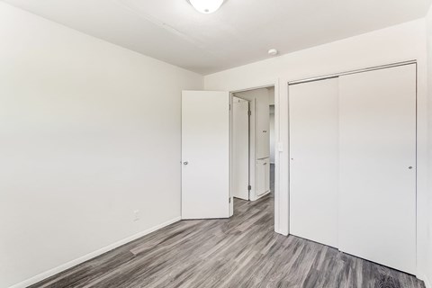 a bedroom with white walls and sliding closet doors