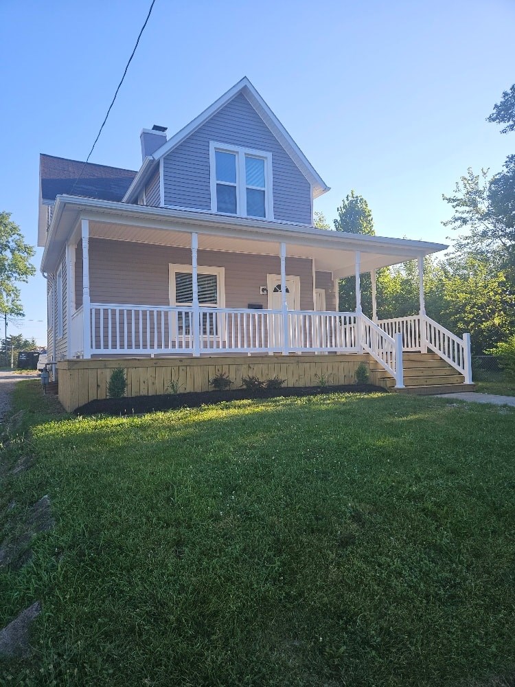 A house with a blue roof and white porch.