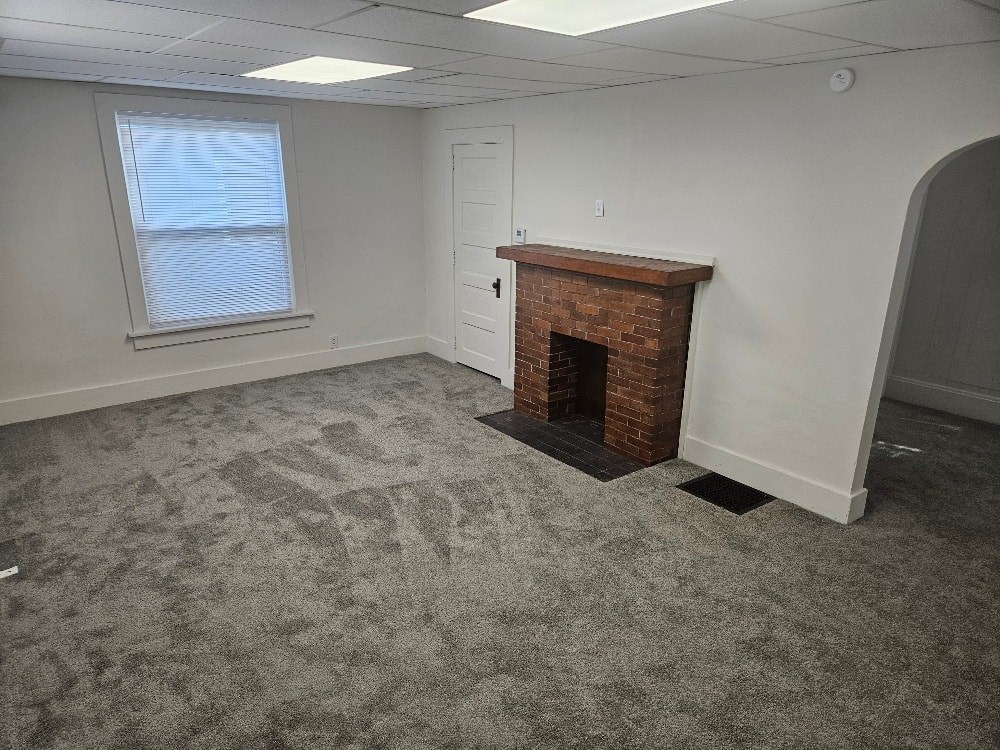 A room with a fireplace and a window.