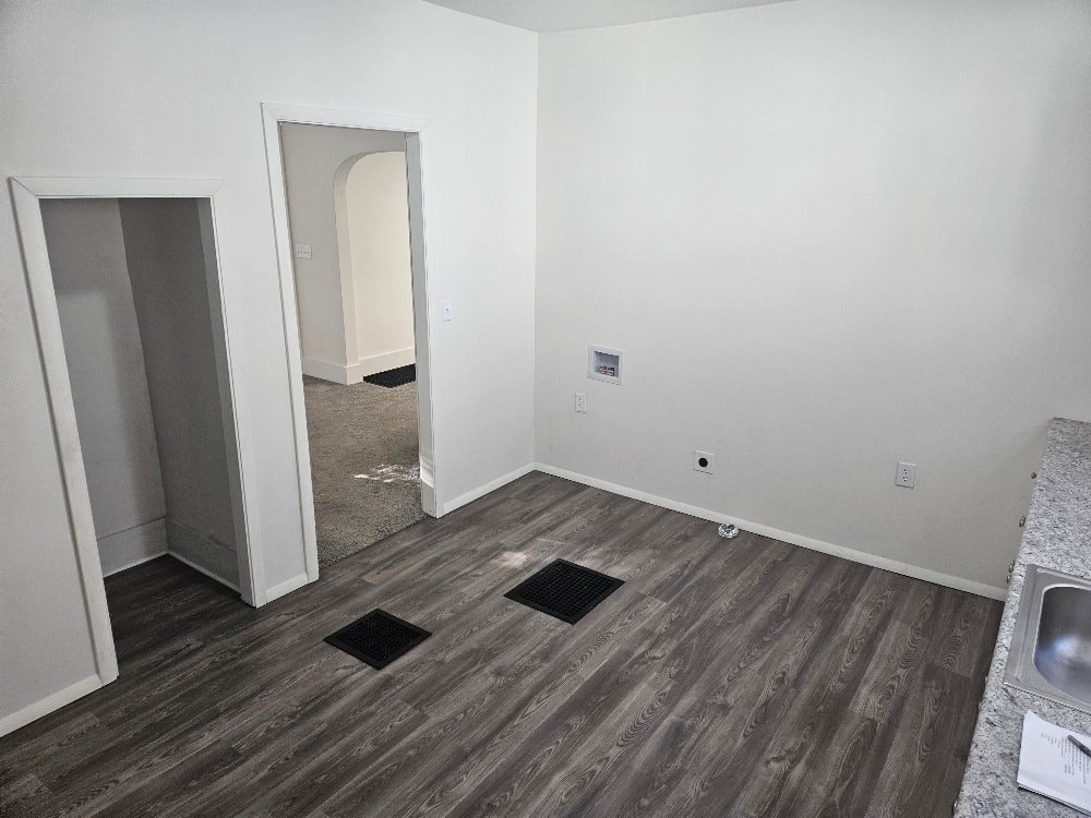 A room with a sink and a doorway leading to another room.