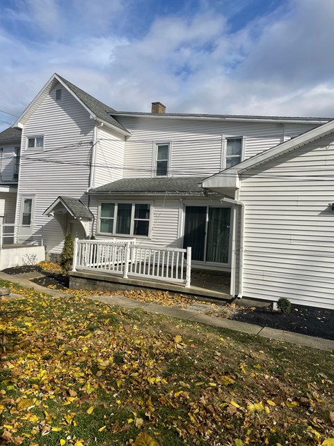 A house with a white porch and a brown roof.