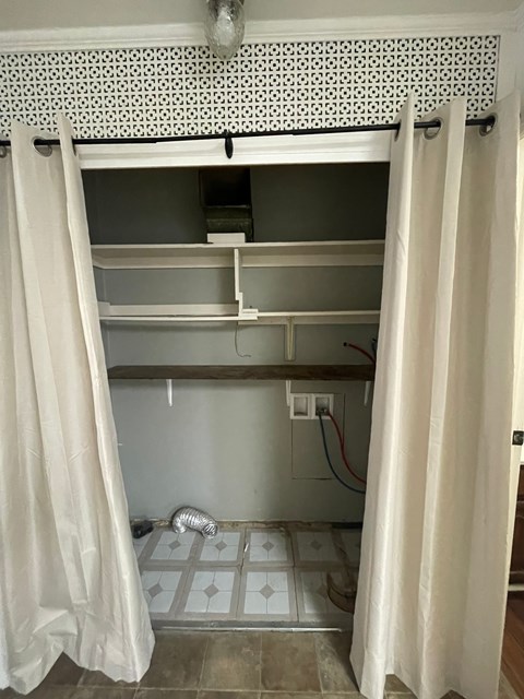 A bathroom with a white shower curtain and a white tile floor.