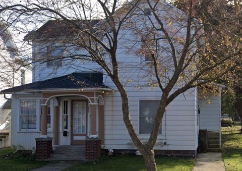 a white house with a tree in front of it
