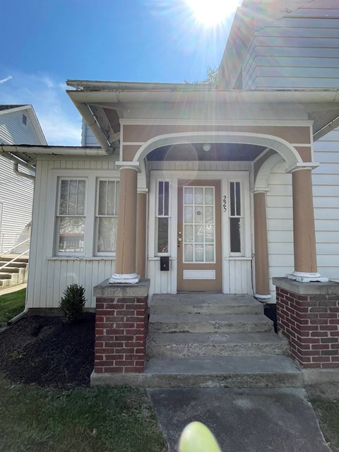 the front of a house with a white door and a porch