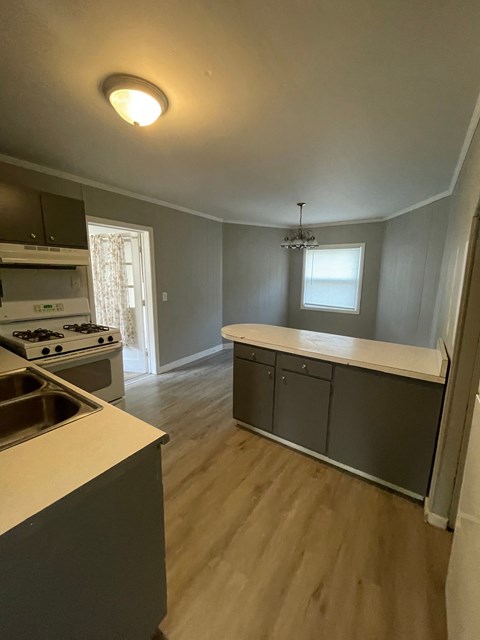a kitchen with an island and a stove and a window