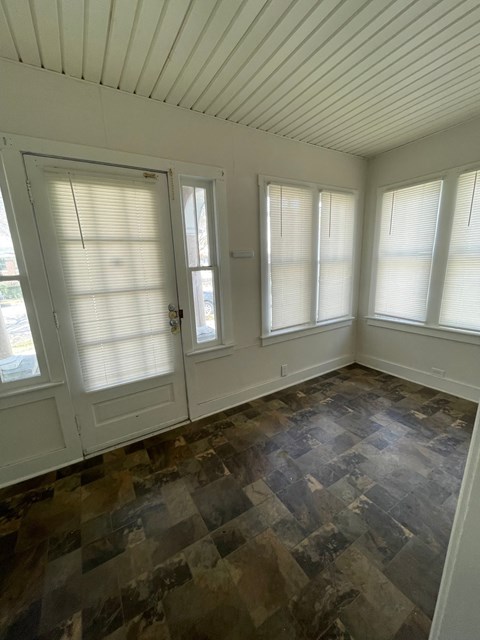 an empty room with three windows and a door