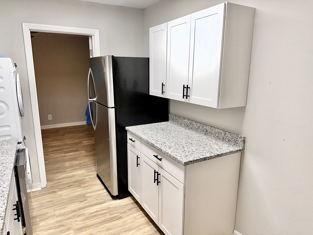 a kitchen with white cabinets and a stainless steel refrigerator
