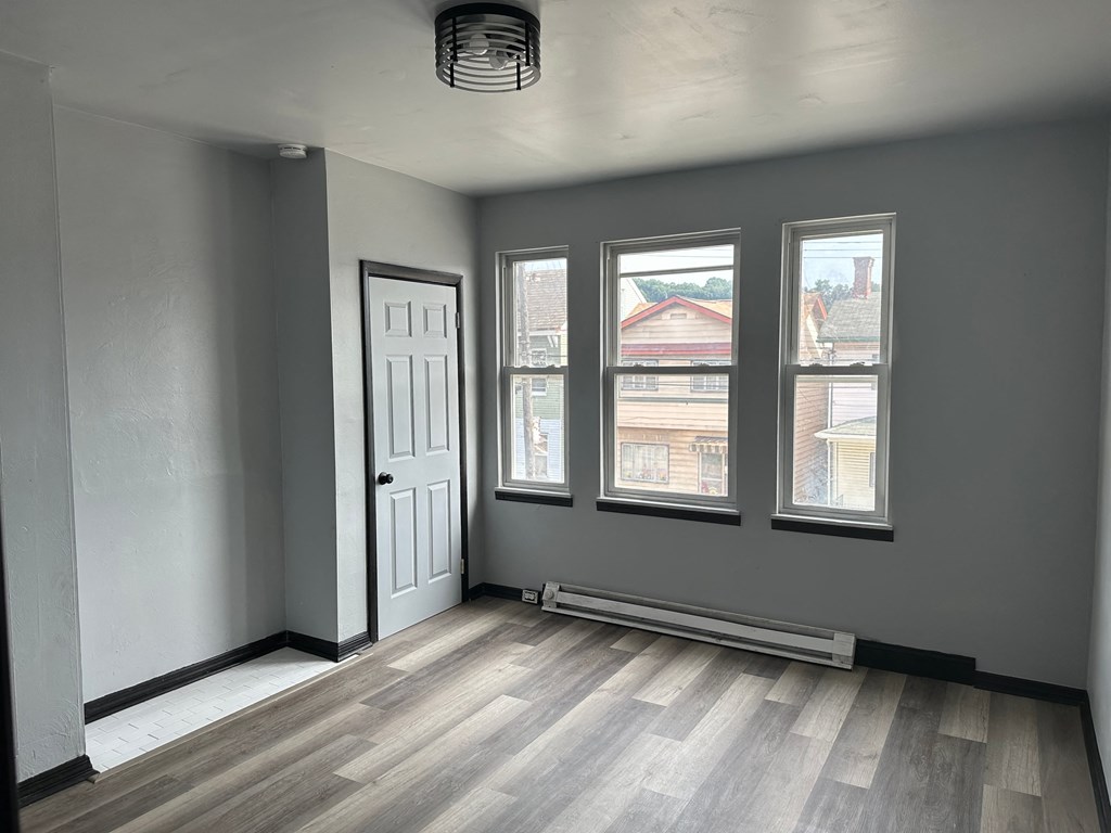 an empty room with a door and three windows