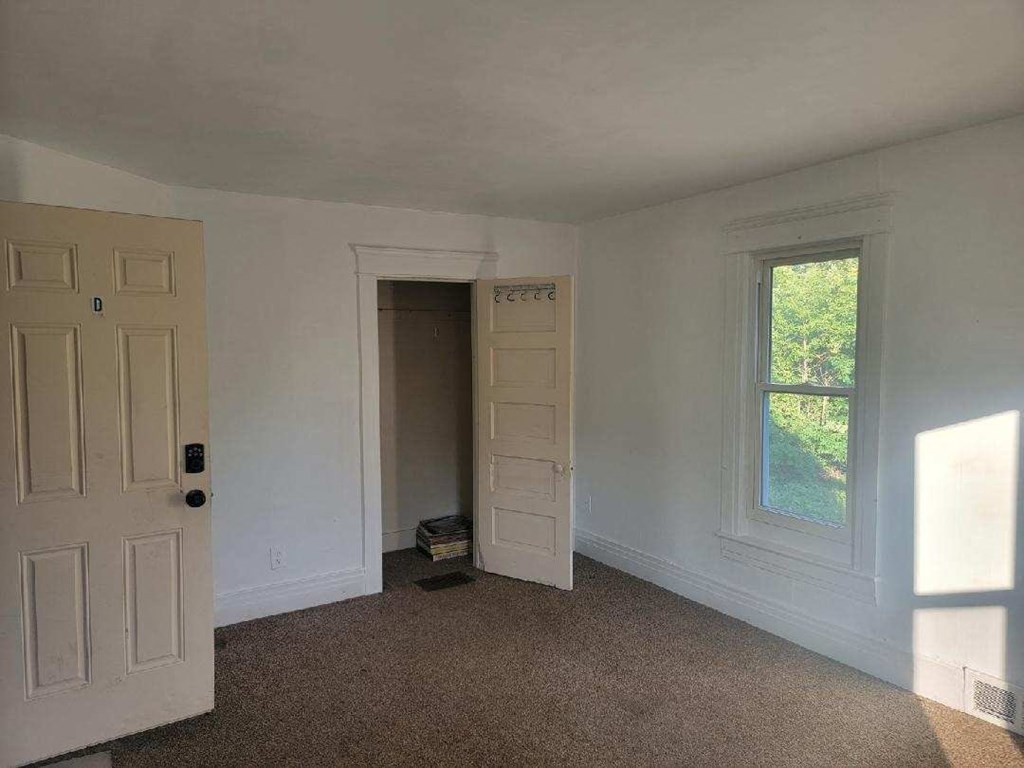 an empty room with a door and a window