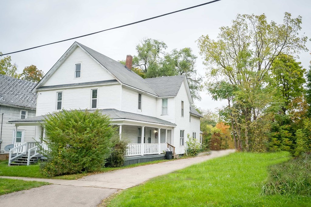a white house with a sidewalk in front of it