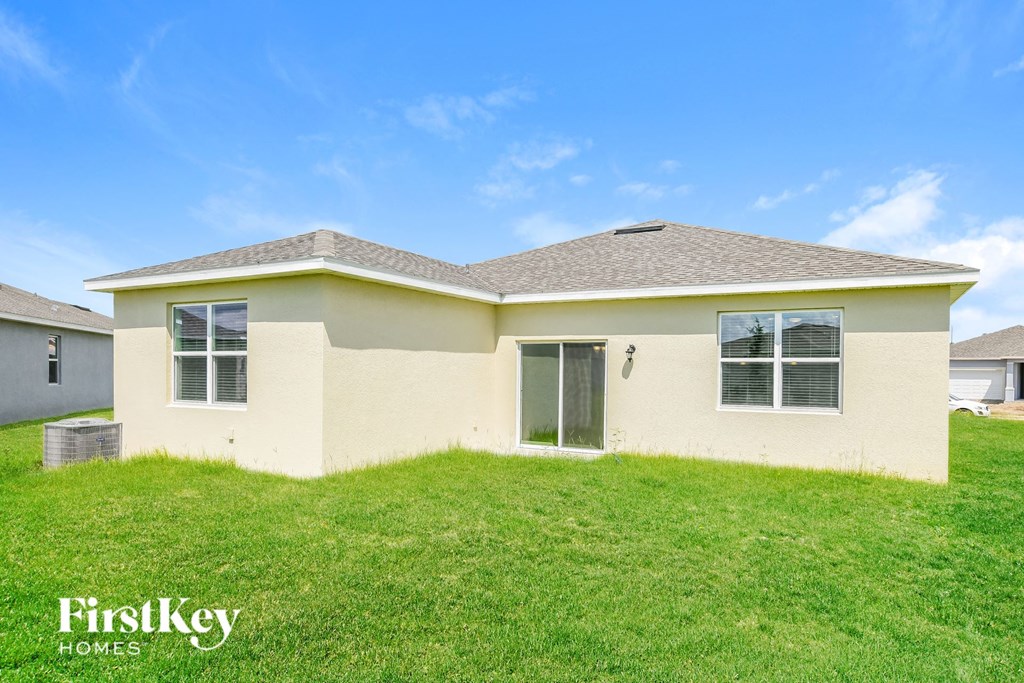 a beige house with a lawn in front of it