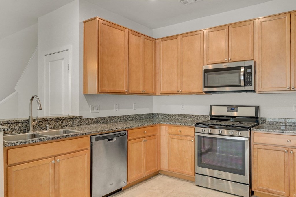 a kitchen with wooden cabinets and stainless steel appliances