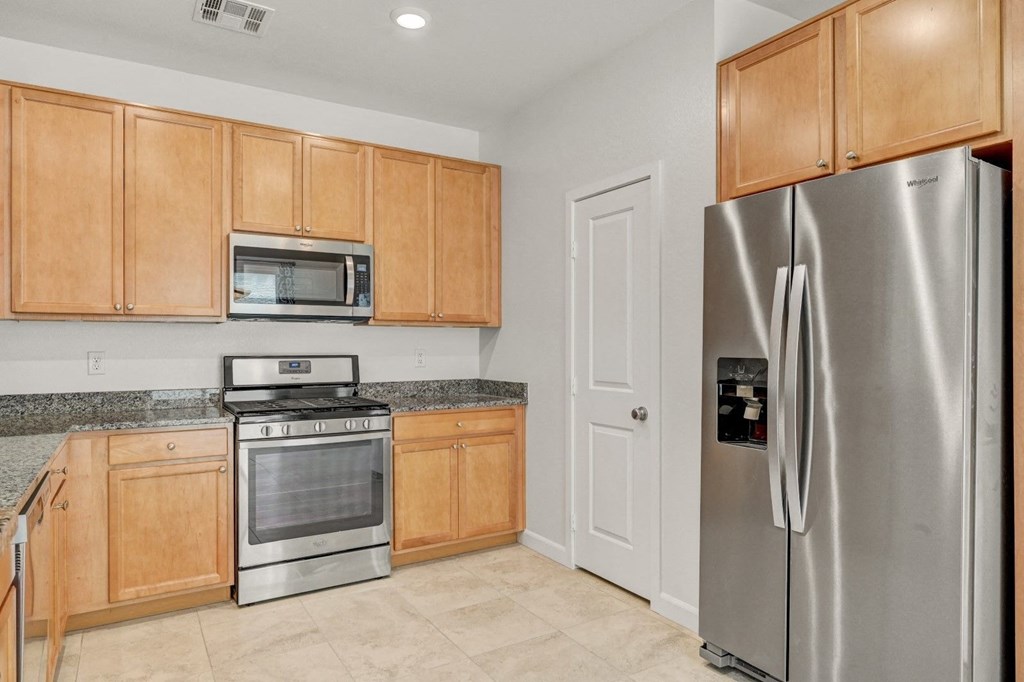 a kitchen with stainless steel appliances and wooden cabinets