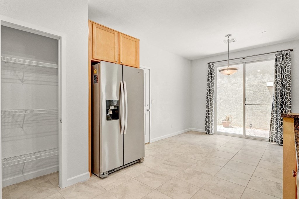 a kitchen with a stainless steel refrigerator and a sliding glass door