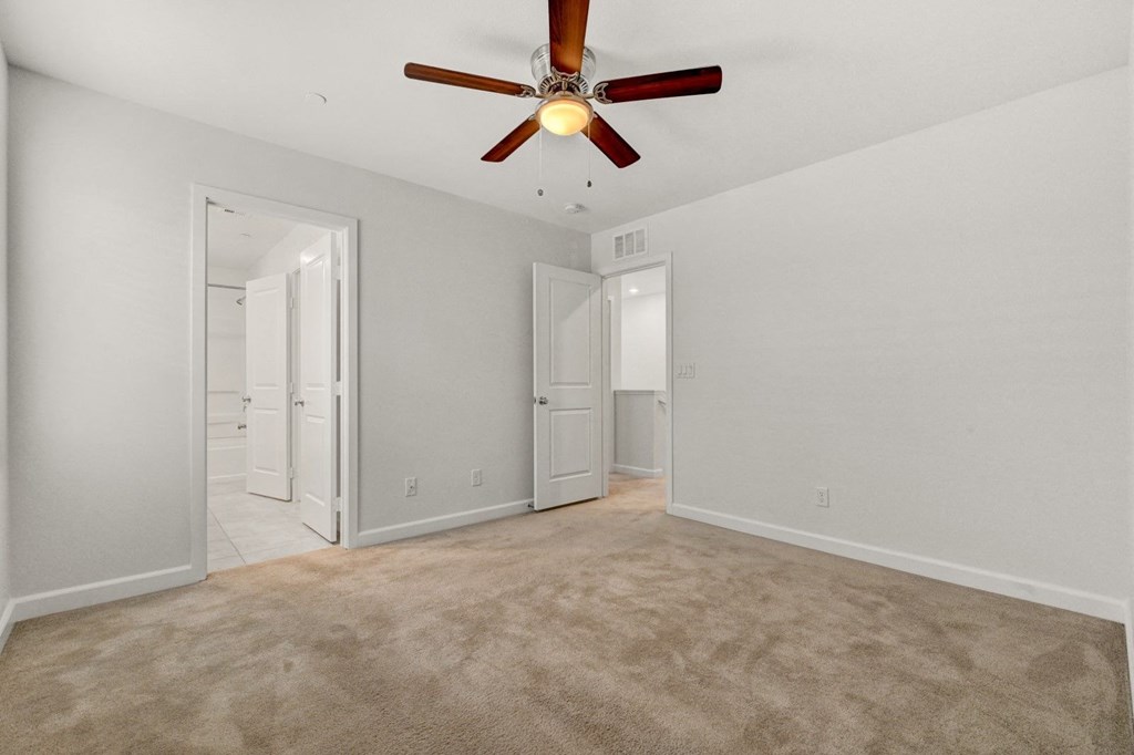 an empty living room with a ceiling fan