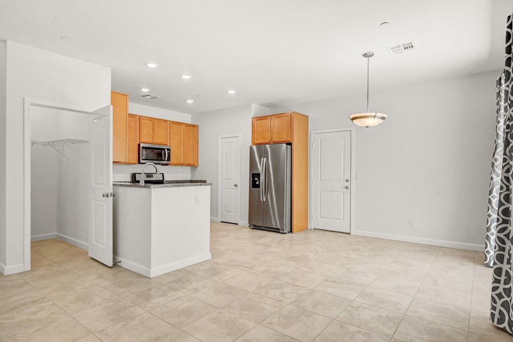 an empty kitchen with a stainless steel refrigerator