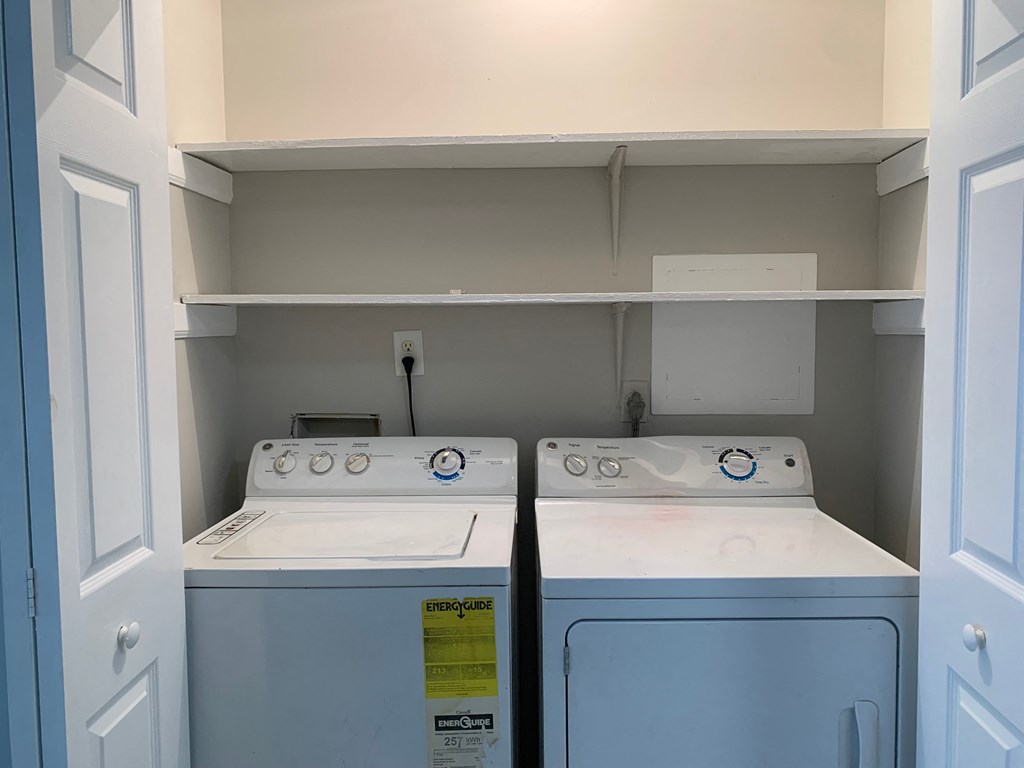 two washers and dryers in a laundry room with two doors