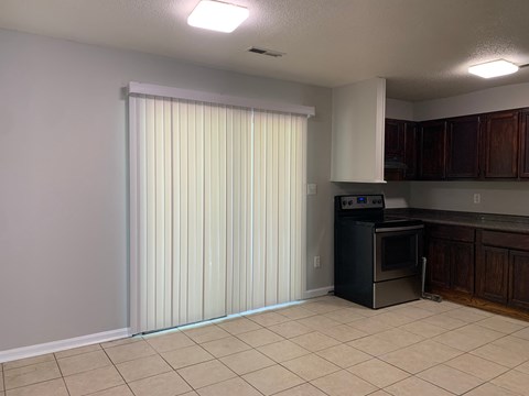 a kitchen with a refrigerator and a stove and a window