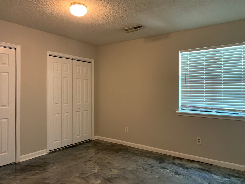 an empty room with a window and a door and a carpeted floor