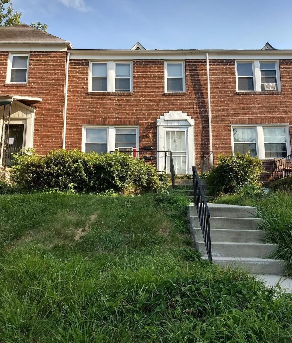 the front of a brick house with stairs in front of it
