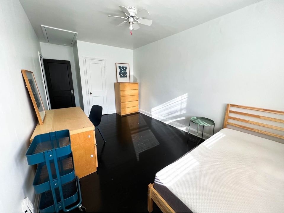 a bedroom with a bed and a desk in a room