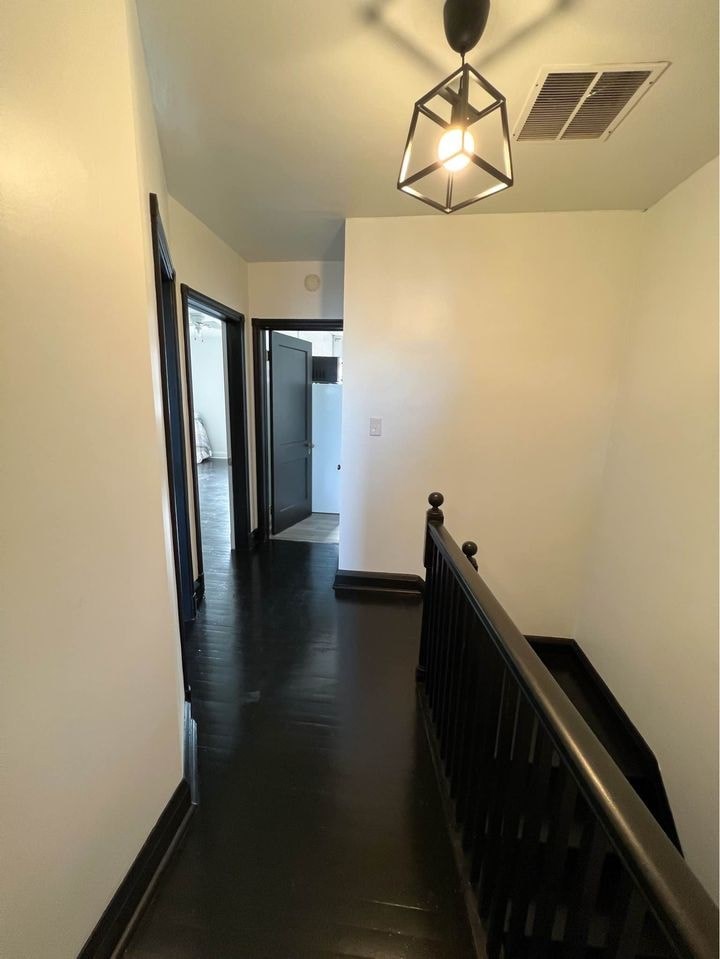 a hallway with a staircase and a hall way with a light and a door