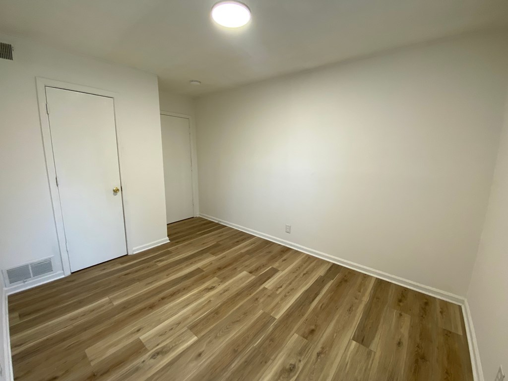 A room with a wooden floor and a white door.