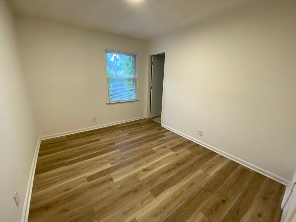 A room with wooden flooring and a window.