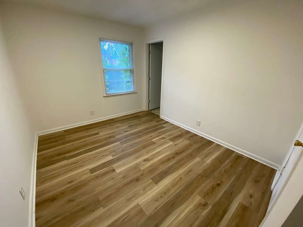 A room with wooden flooring and a window.