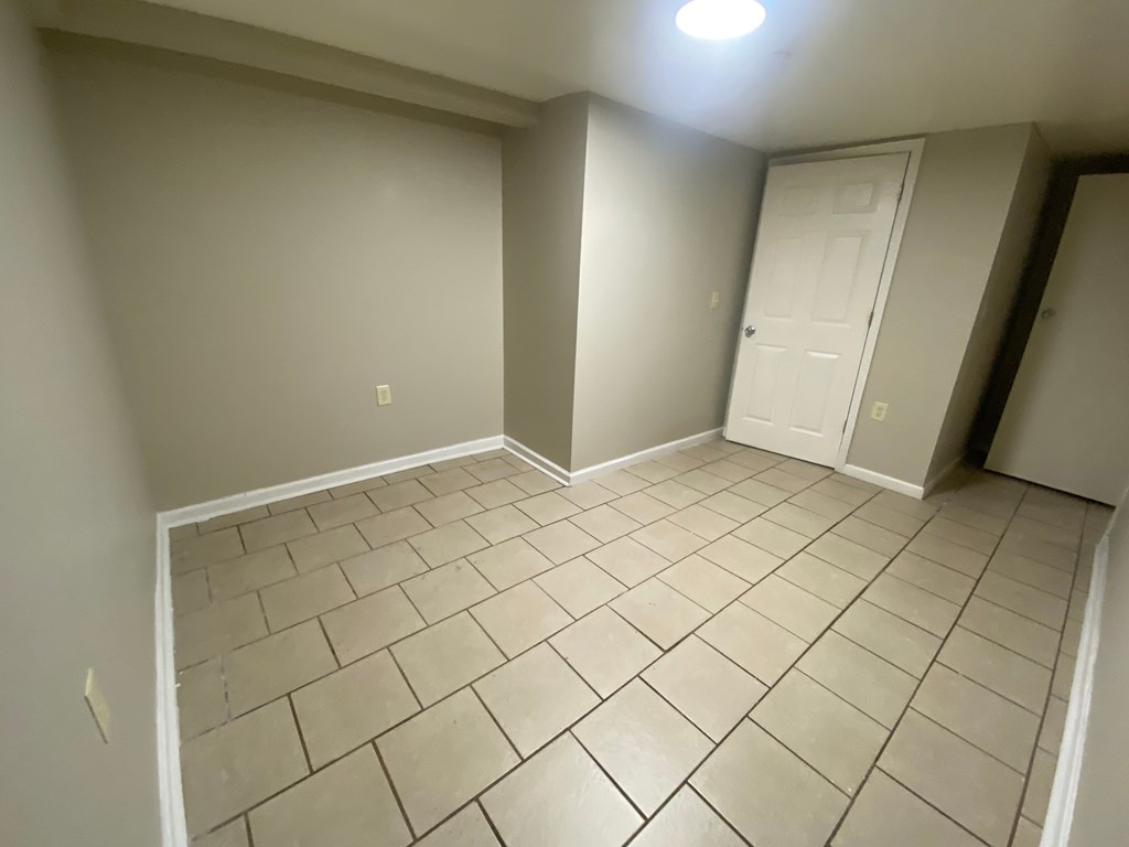 A room with a tiled floor and a white door.
