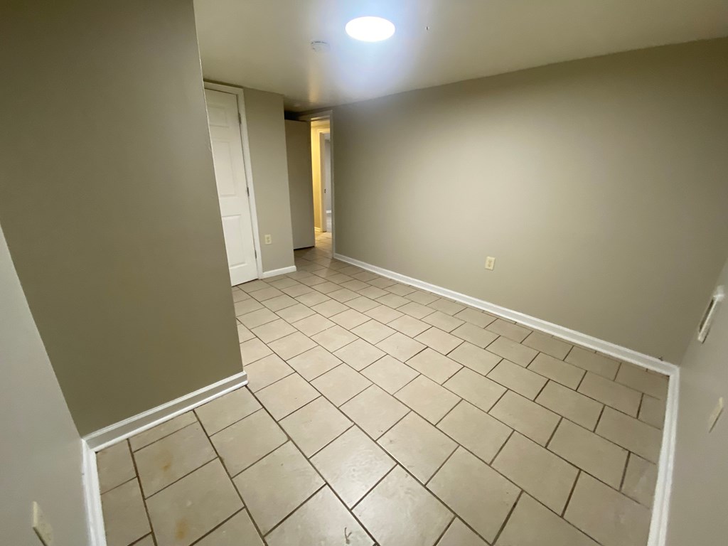 A room with tiled flooring and a single light fixture on the ceiling.